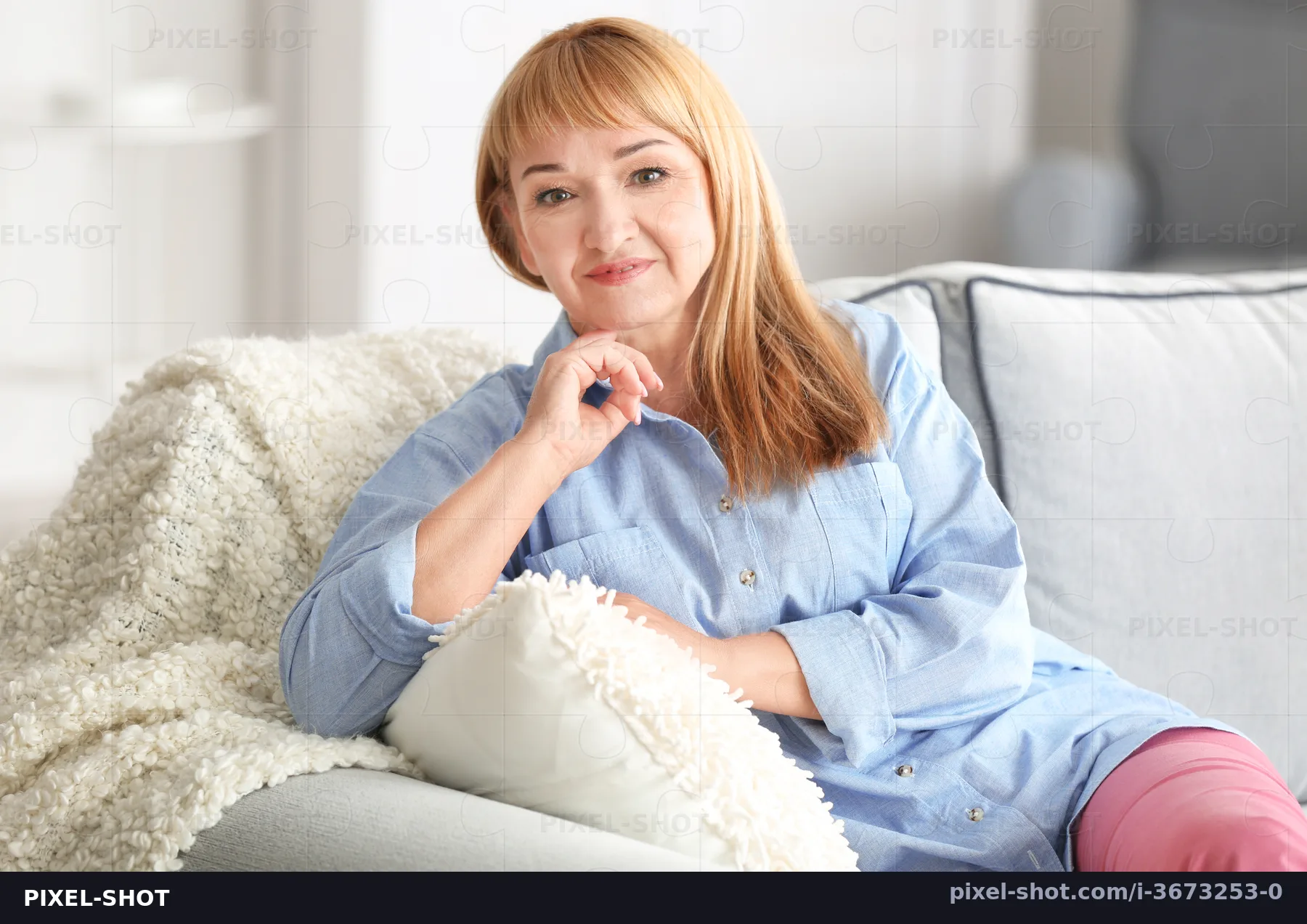 Тощая зрелая женщина на диване